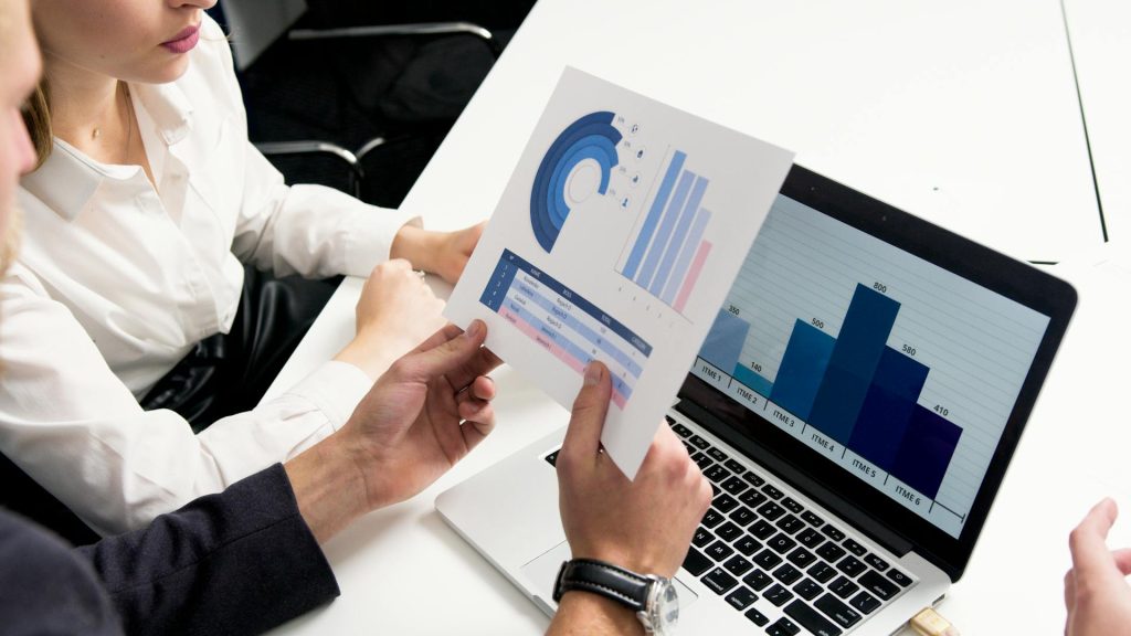 Business professionals discussing growth planning with printed charts and digital reports