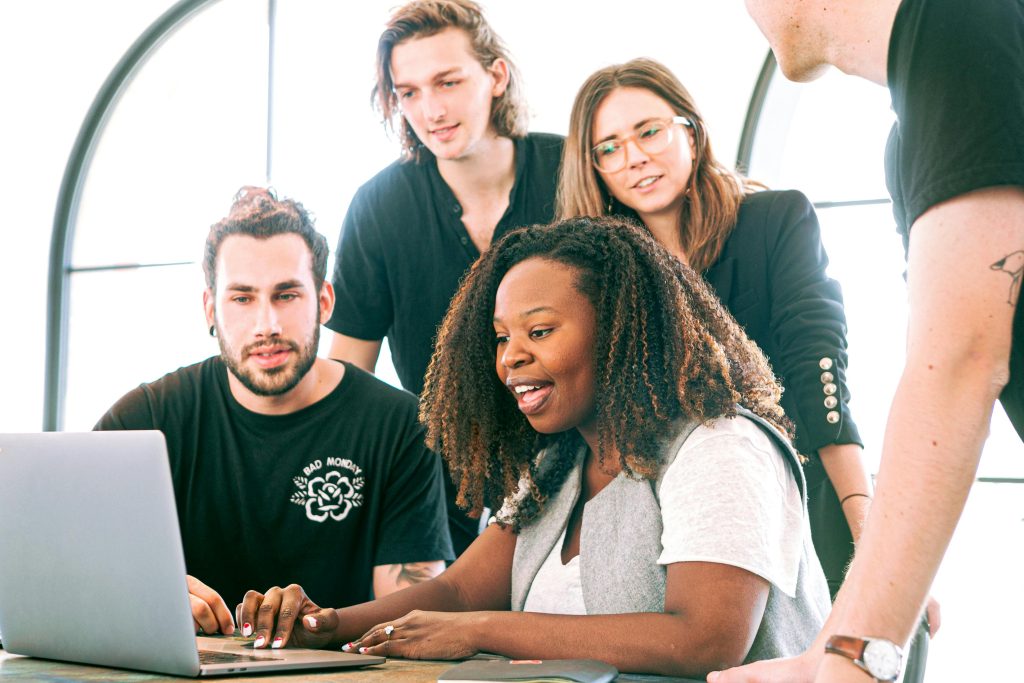 Team of professionals collaborating around a laptop during a Toronto business meeting