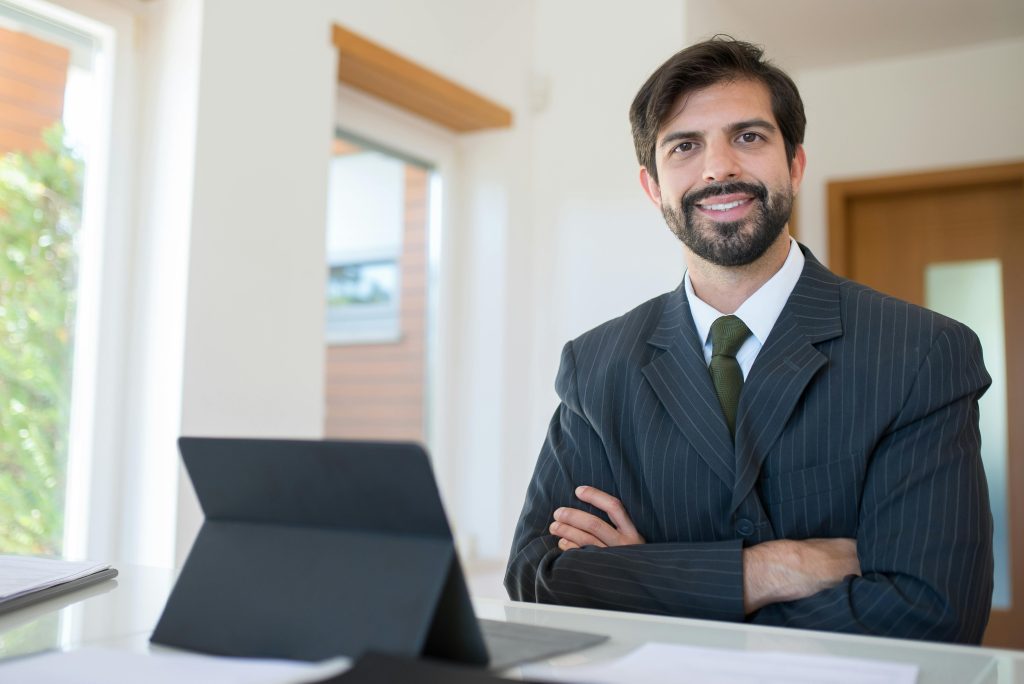 Professional real estate agent smiling at desk
