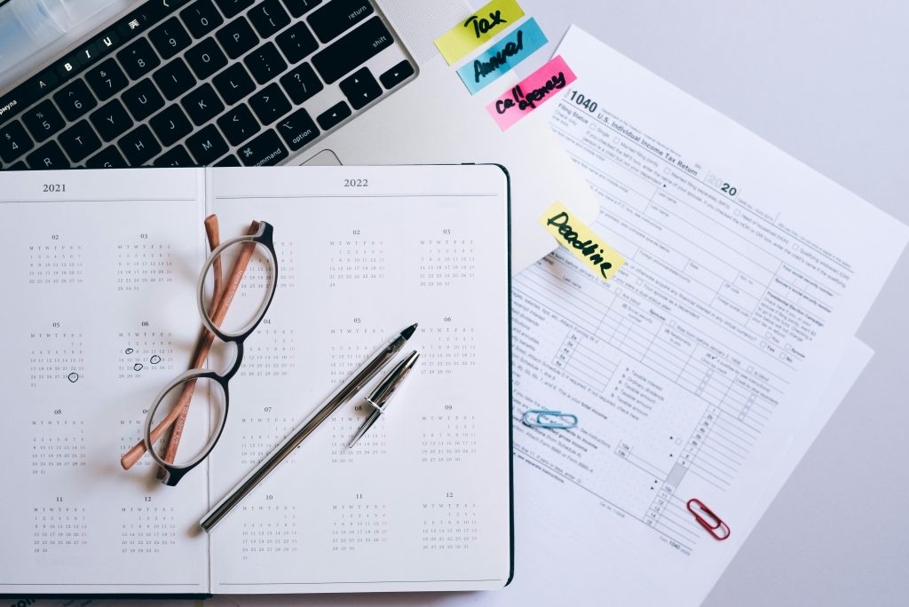Real estate financial planning with calendar, documents, and laptop on desk