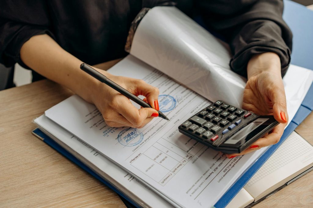 Real estate financial compliance check with calculator and paperwork