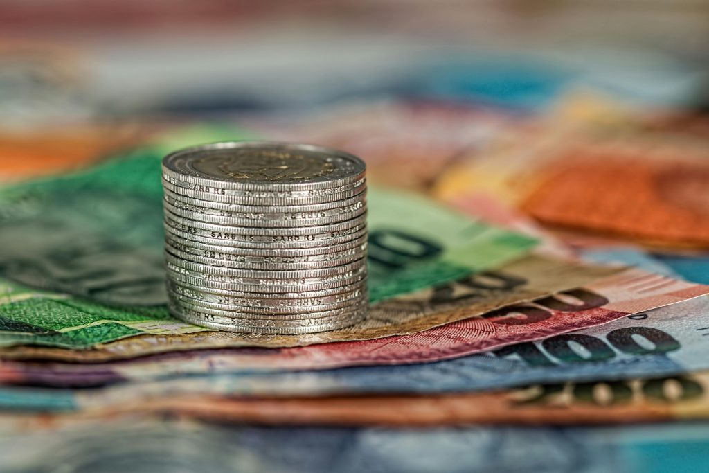 tack of money with coins symbolizing real estate commission tracking