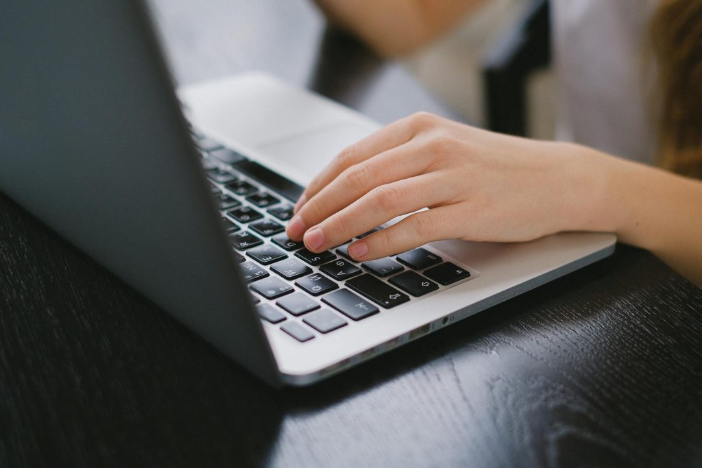Professional writing real estate copy and messaging on laptop
