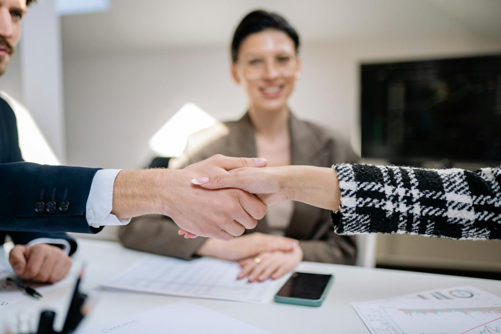 Business professionals shaking hands during interview coordination