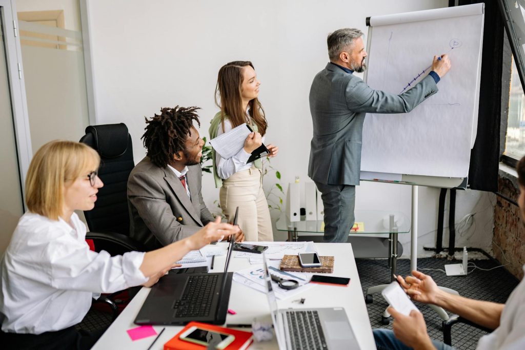 Team leader coaching colleagues during business training session with flip chart